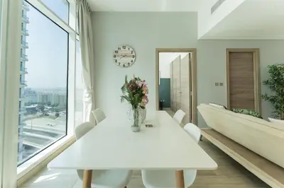 a white dining room with a table and a large window at HAVN - 2 Bedroom Apartment with Dubai Marina View in Dubai