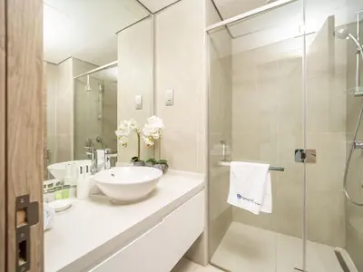 a bathroom with a sink and a glass shower at HAVN - 2 Bedroom Apartment with Dubai Marina View in Dubai