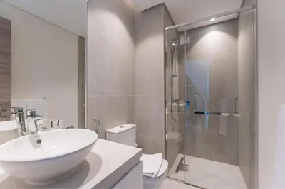a white bathroom with a sink and a shower at HAVN - 2 Bedroom Apartment with Dubai Marina View in Dubai