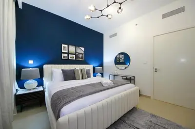 a bedroom with a blue accent wall and a bed at RH- Luxury Living, Central 1-Bedroom near DIFC, High Floor, 8 mins walk to Dubai Mall in Dubai