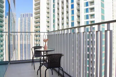 a balcony with two chairs and a table with a vase on it at RH- Luxury Living, Central 1-Bedroom near DIFC, High Floor, 8 mins walk to Dubai Mall in Dubai