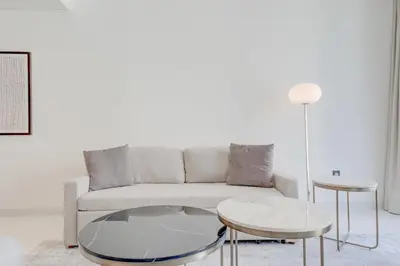 a living room with a couch and two tables at Silkhaus Exquisite Sea View 1BDR At Marina Vista in Dubai