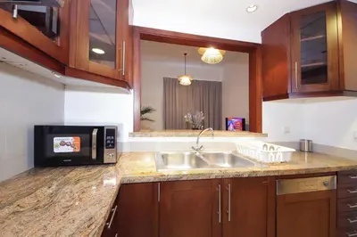 a kitchen with a sink and a microwave at New Arabian The Links Canal 1 BR The Greens in Dubai