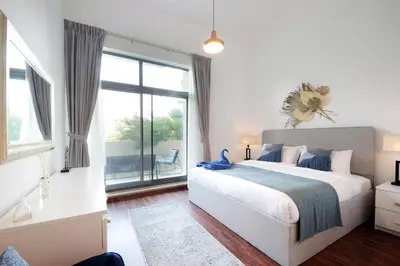 a bedroom with a large bed and a large window at New Arabian The Links Canal 1 BR The Greens in Dubai