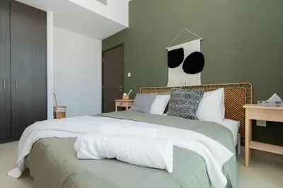 a bedroom with a large bed with white sheets and pillows at Elite Escape Holiday Home - 2 BHK Getaway with Burj Khalifa View and Dubai Mall Access - 1507 in Dubai