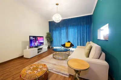 a living room with a couch and a tv at RH- High-Floor Splendor, 2-Bedroom Gem in Downtown in Dubai