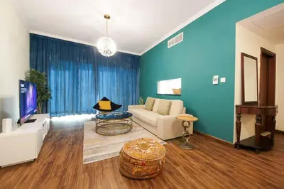 a living room with a couch and a tv at RH- High-Floor Splendor, 2-Bedroom Gem in Downtown in Dubai