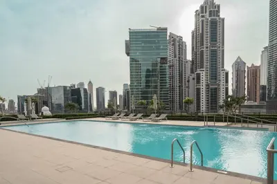a large swimming pool in a city with tall buildings at Prime Retreats @ Burj Crown by Emaar, Downtown dubai in Dubai