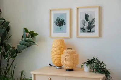 a table with two pictures on a wall with plants at Elite Escape Holiday Home - 2 BHK Getaway with Dubai Mall Access - 1508 in Dubai