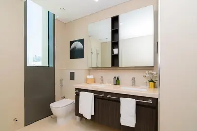 a bathroom with a toilet and a sink and a mirror at Elite Escape Holiday Home - 2 BHK Getaway with Dubai Mall Access - 1508 in Dubai