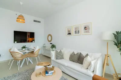 a living room with a white couch and a table at Elite Escape Holiday Home - 2 BHK Getaway with Dubai Mall Access - 1508 in Dubai