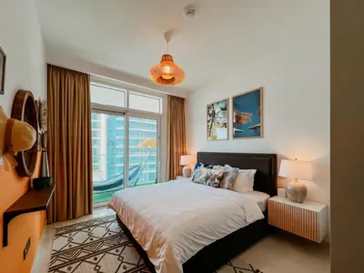 a bedroom with a bed and a large window at Oceanfront Escape: Stylish 1 BR in Beachfront in Dubai
