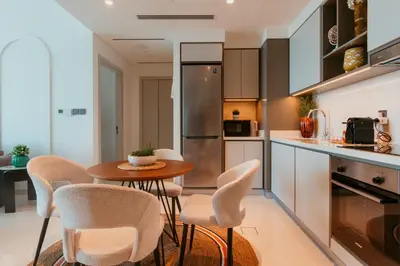 a kitchen with a table and chairs in a room at Oceanfront Escape: Stylish 1 BR in Beachfront in Dubai