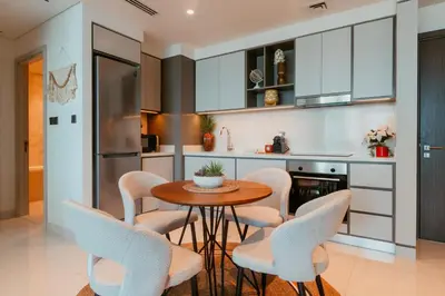 a kitchen with a wooden table and chairs at Oceanfront Escape: Stylish 1 BR in Beachfront in Dubai