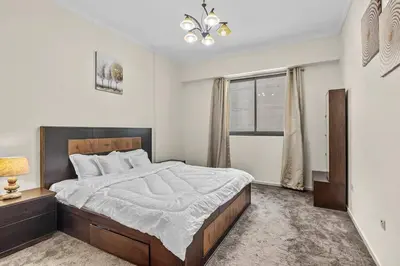 a bedroom with a large bed and a window at Modern living nestled with 1BR_Silicon Oasis Dubai in Dubai