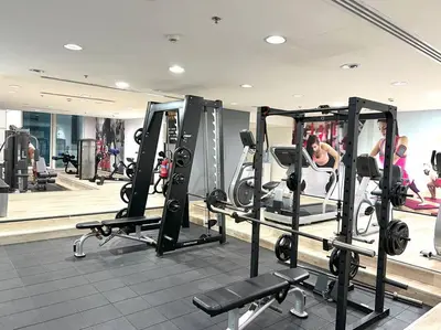 a gym with several tread machines and people in the background at 1 BR Flat, Luxury amenities, Near JBR Beach & Club with FREE Parking in JBR in Dubai