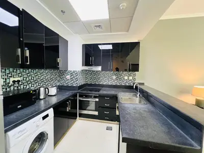 a kitchen with black and white tile on the wall at 1 BR Flat, Luxury amenities, Near JBR Beach & Club with FREE Parking in JBR in Dubai