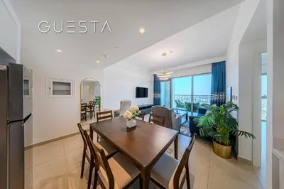 a dining room and living room with a table and chairs at Downtown Views II by Emaar, Downtown Dubai in Dubai