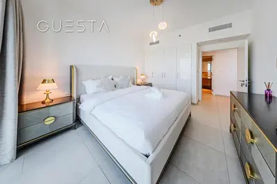 a white bedroom with a large white bed in it at Downtown Views II by Emaar, Downtown Dubai in Dubai