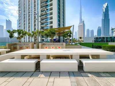a large white table and benches in a city at Downtown Views II by Emaar, Downtown Dubai in Dubai