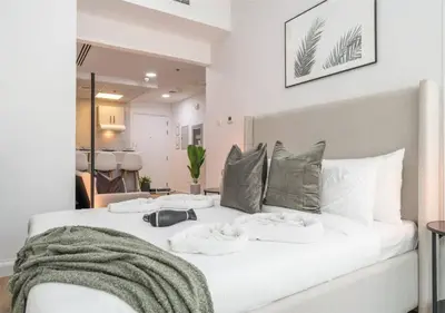 a white bed with two pillows on it in a room at HAVN - Studio Apartment in JLT, with Lake Views in Dubai