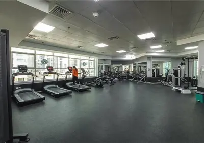 a person in a gym with several tread machines at HAVN - Studio Apartment in JLT, with Lake Views in Dubai