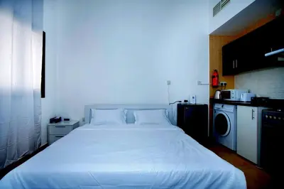 a large white bed in a small room at Your Silicon Oasis Comfort Haven in Dubai