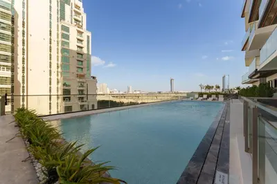 a swimming pool in the middle of two buildings at Luxury Living in 1 bedroom apartment in JVC in Dubai