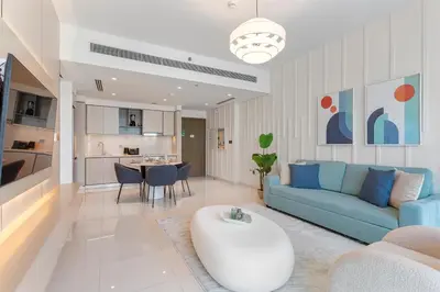 a living room with a blue couch and a table at Luxury beach house with mesmerizing skyline view in Dubai