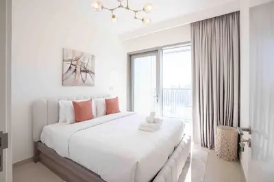 a white bedroom with a large bed and a window at Downtown Views II Burj Khalifa View, Downtown Dubai - Mint Stay in Dubai