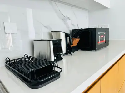 a kitchen counter with a toaster oven and a microwave at Luxury Brand New 2 Bhk Apartment In La Vie -jbr in Dubai