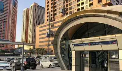 a building with cars parked in a parking lot at Blooming Partition Room in Tecom Near Internet City Metro in Dubai
