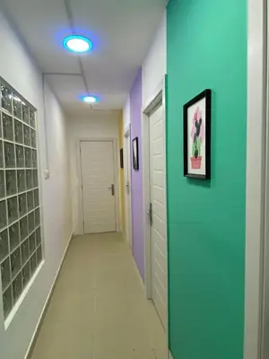 a hallway with a blue and purple wall and a door at Blooming Partition Room in Tecom Near Internet City Metro in Dubai