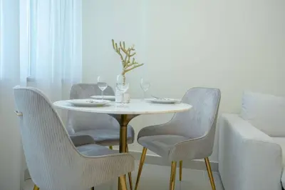 a dining room table with chairs and a vase on it at Cozy Spacious Apartment 1BR in Dubai