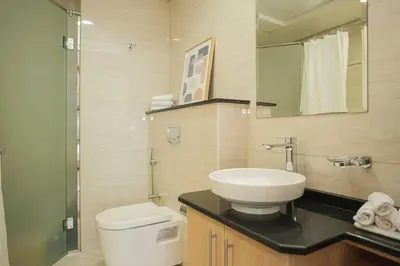 a bathroom with a sink and a toilet and a mirror at Cozy Spacious Apartment 1BR in Dubai