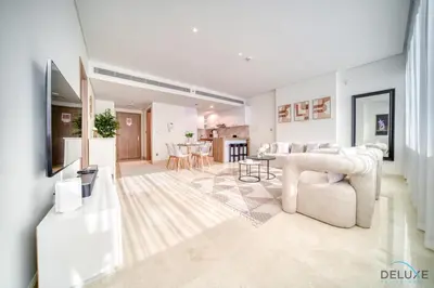a living room with a couch and a table at Special Offer Stylish 1BR with Scenic Views & Pool by Deluxe Holiday Homes in Dubai