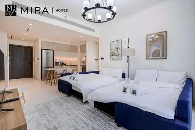 a bedroom with two beds and a living room at Mira Holiday Homes-Marina Vista Emaar Beachfront in Dubai