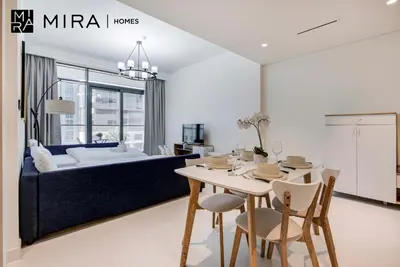 a living room with a dining table and a bed at Mira Holiday Homes-Marina Vista Emaar Beachfront in Dubai