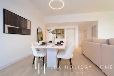 a dining room with a white table and white chairs at LUX The Dubai Eye Sea View Suite in Dubai