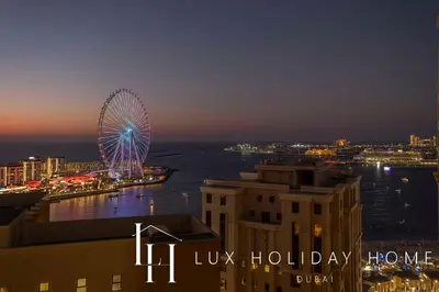a ferris wheel in a city at night at LUX The Dubai Eye Sea View Suite in Dubai
