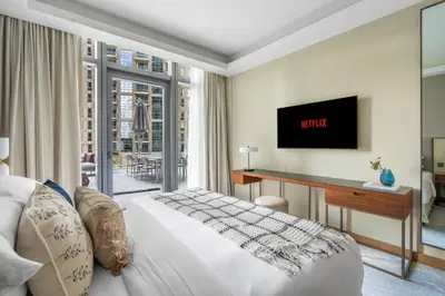 a bedroom with a bed and a desk and a television at GuestReady - Contemporary delight in Dubai in Dubai