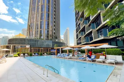 a swimming pool with chairs and umbrellas in a city at GuestReady - Contemporary delight in Dubai in Dubai