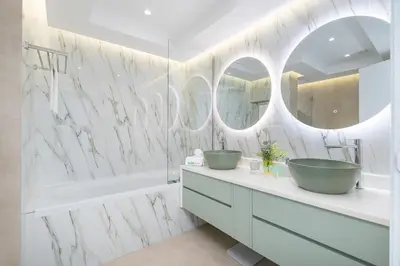 a bathroom with two sinks and two mirrors at Astonishing 2 bedroom apt full Burj Khalifa view in Dubai