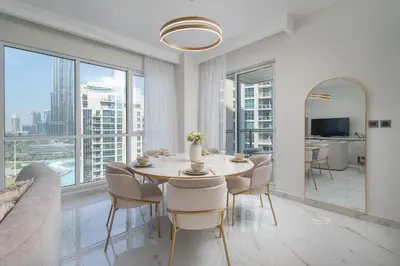 a dining room with a table and chairs and windows at Astonishing 2 bedroom apt full Burj Khalifa view in Dubai