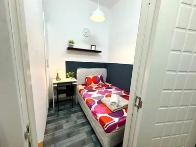 a small bedroom with a bed and a desk at Deluxe Couple Partition Room in Tecom Near Metro in Dubai