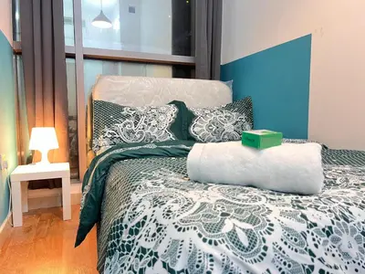 a bedroom with a bed with a blue and white comforter at Relaxing Closed Partition Room in Tecom Near Metro in Dubai
