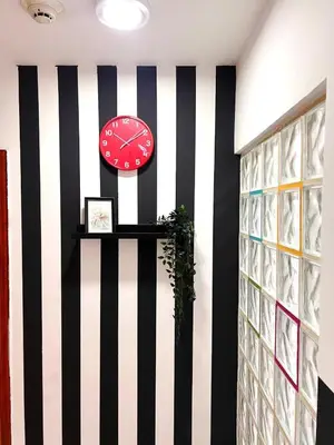 a clock on a wall with black and white stripes at Relaxing Closed Partition Room in Tecom Near Metro in Dubai