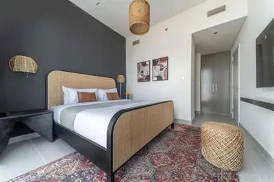 a bedroom with a large bed and a chair at Frank Porter - Forte Tower 1 in Dubai