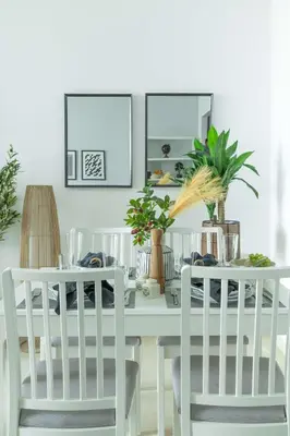 a white dining room table with two chairs and a mirror at Frank Porter - Torch Tower in Dubai