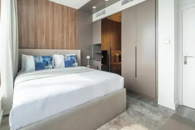 a bedroom with a large white bed with blue pillows at Frank Porter - Burj Views Central Tower in Dubai